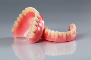 A set of dentures on a shiny gray background